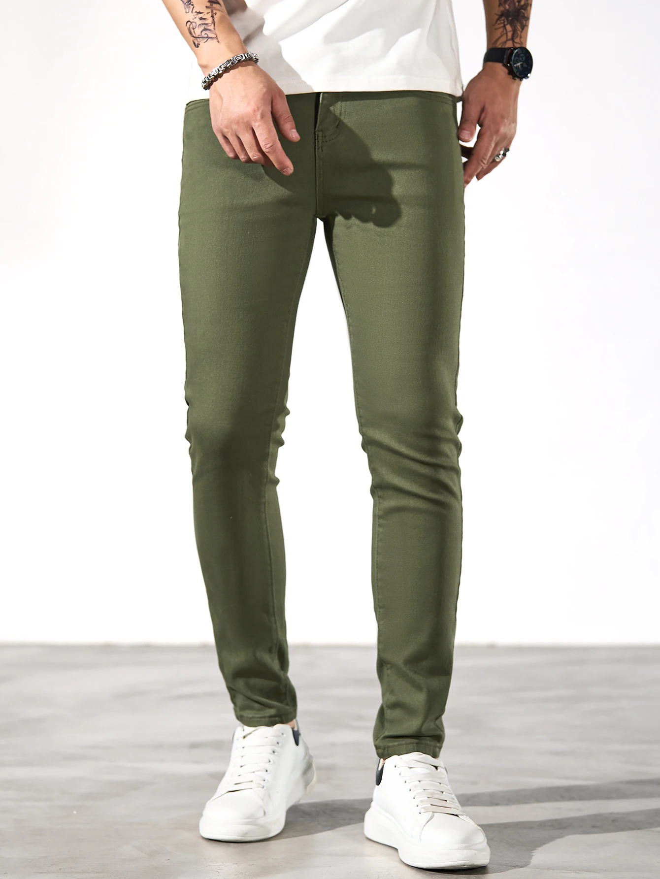 Fashionable men's skinny jeans. Army green straight skinny trousers. Casual street men's jeans.